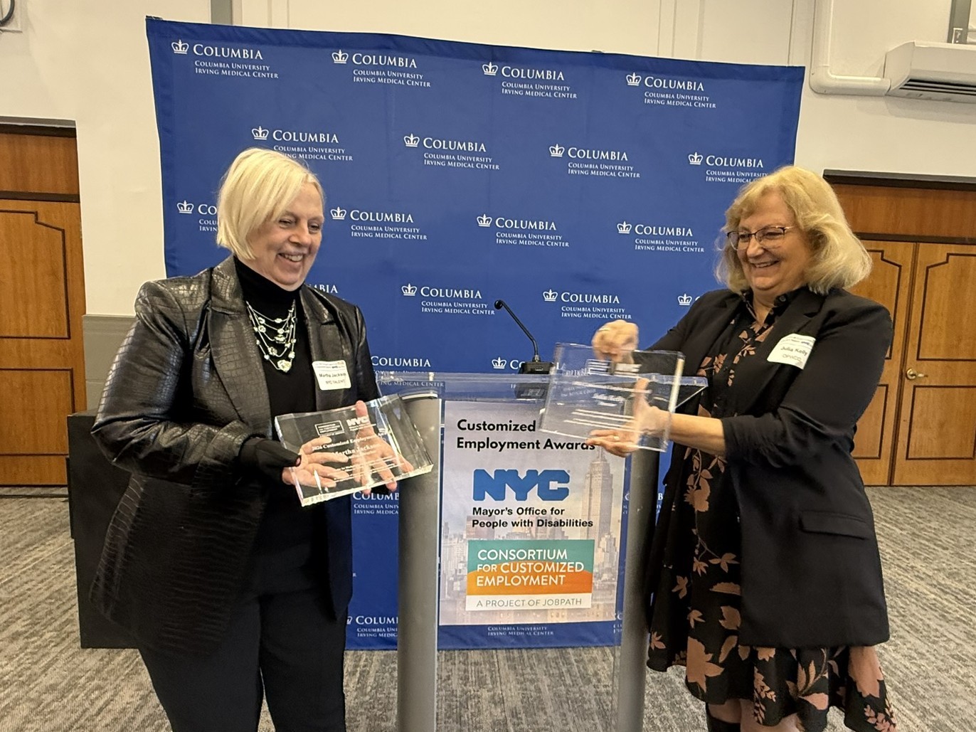 Martha Jackson & Julia Kelly in front of a podium at the 2026 CCE Awards.