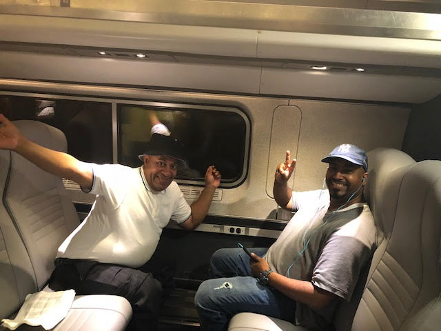 Robert and Carlos sitting on a train to Albany.