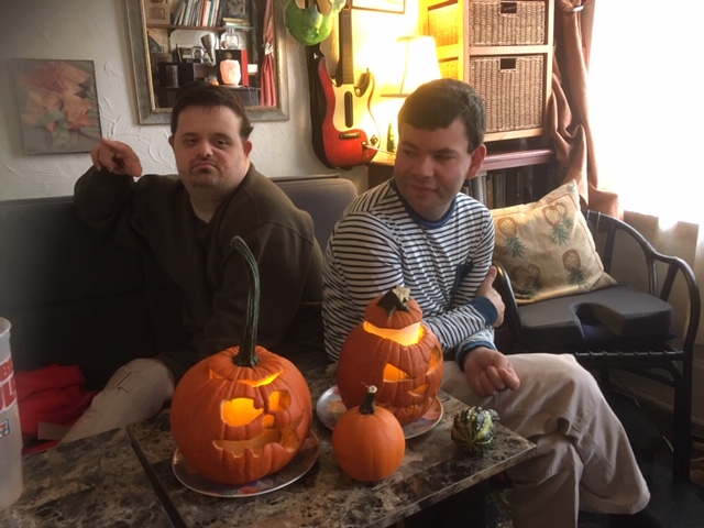 Job Path participants showing their handmade Halloween pumpkin decorations at home.