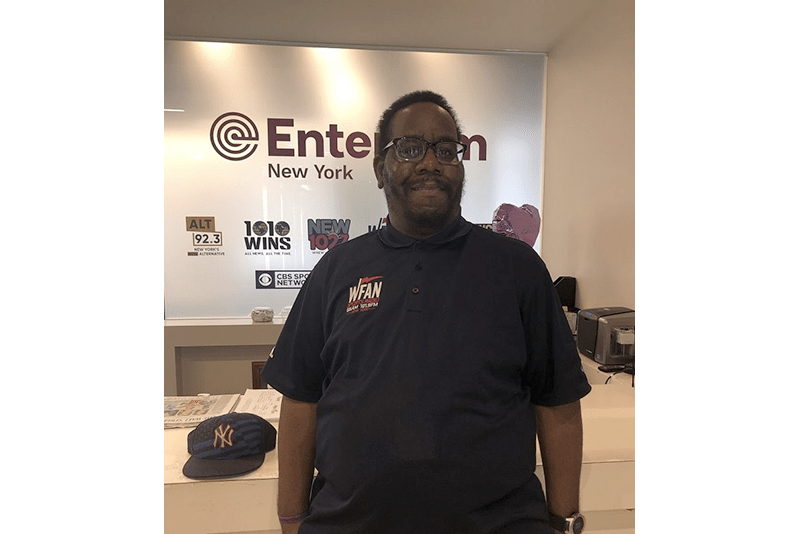 Will, a Black man, inside his workplace, Entercom