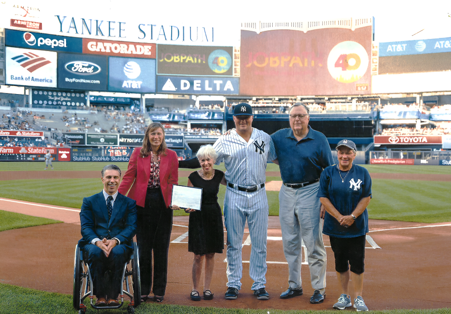 Victor Calise, Fredda Rosen, Dan Cunningham and Carolann Granata are present at Yankees stadium field. They were honored by the Yankees during Autism Awareness Day. A Yankees player is standing to the left of Dan Cunningham.